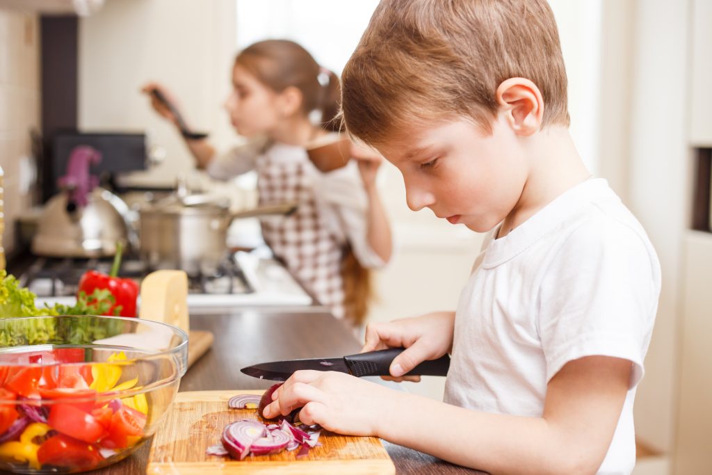 Small boy and his sister cooking in the kitchen